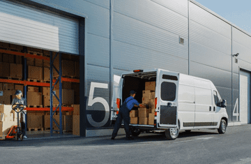 A warehousing and fulfillment services employee loading boxes into a white van